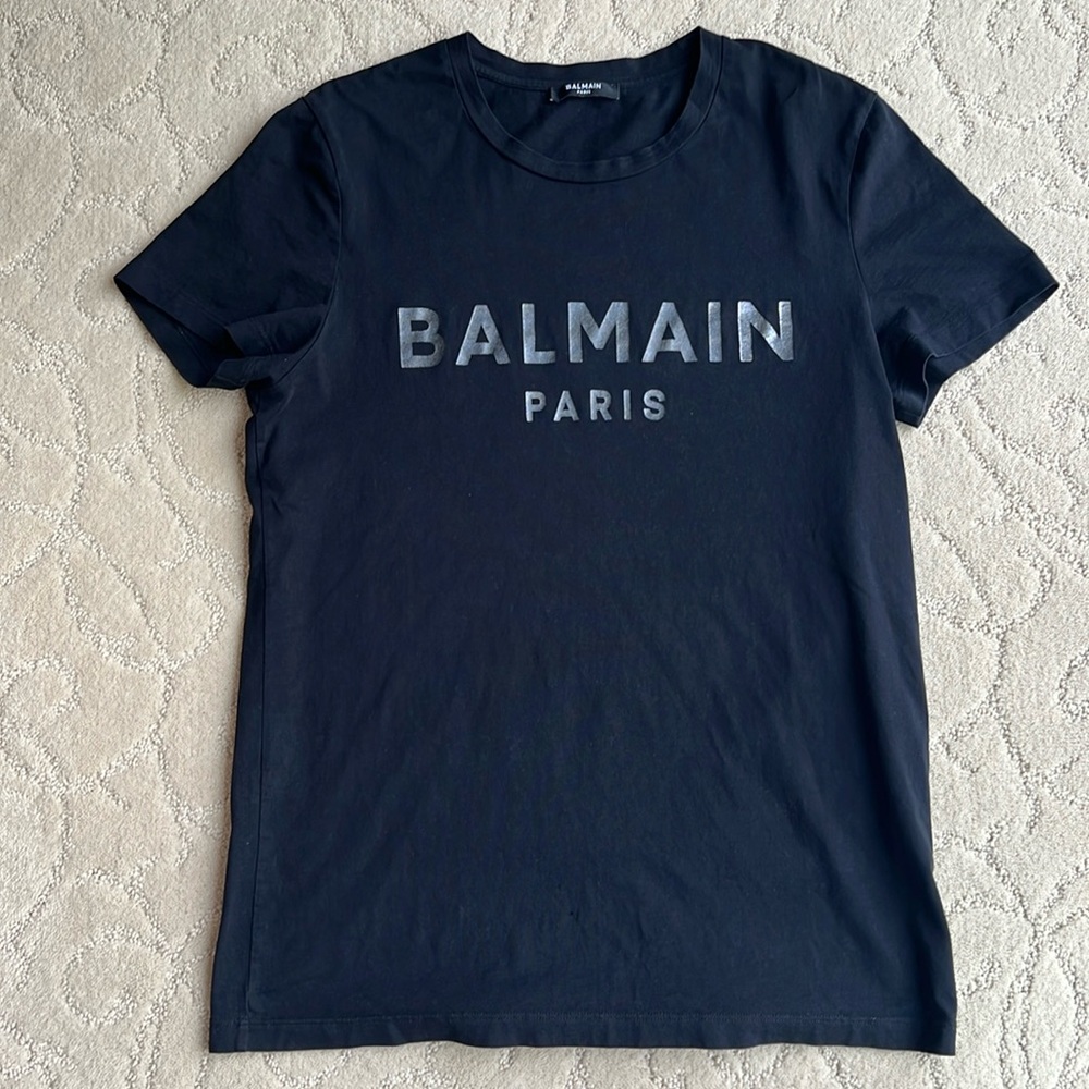 Balmain Black Short Sleeve Tee with silver Bold Logo. Holes at the bottom front